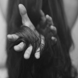 Haare um die Hand einer kaukasischen Frau gewickelt - BLEF07298