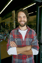 Caucasian man smiling in bicycle shop - BLEF07307