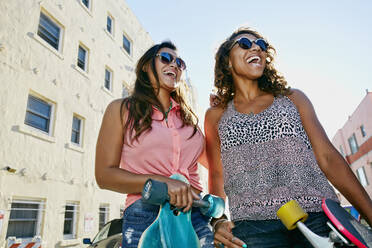 Women laughing on city street - BLEF07314