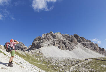 Hiker on hiking trail, Tre Cime di Lavaredo Aera, Nature Park Tre Cime, Unesco World Heritage Natural Site, Sexten Dolomites, Italy - GWF06112