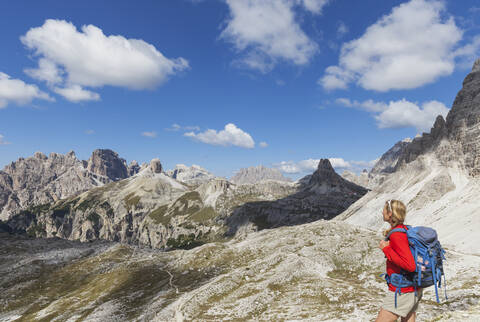 Wanderin mit Blick auf die Aussicht, Gebiet der Drei Zinnen, Naturpark Drei Zinnen, Unesco-Weltnaturerbe, Sextner Dolomiten, Italien, lizenzfreies Stockfoto