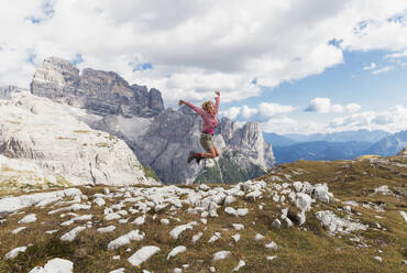 Wanderin beim Springen, Gebiet der Drei Zinnen, Naturpark Drei Zinnen, Unesco-Weltnaturerbe, Sextner Dolomiten, Italien - GWF06127