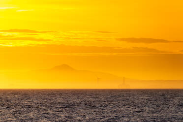 Windkraftanlage und Bohrinsel bei Sonnenuntergang, Fife Coast, Firth of Forth, Schottland - SMAF01256