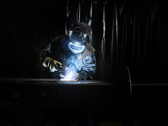 Industriearbeiter in Schutzkleidung beim Schweißen von Metall mit einem Schweißbrenner - CVF01234