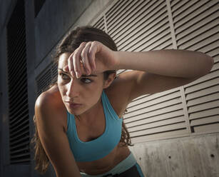 Caucasian runner wiping sweat off forehead - BLEF07420