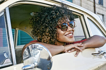 Mixed race woman sitting in vintage car - BLEF07440