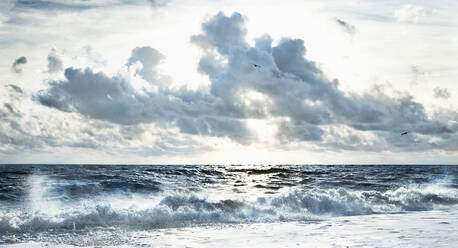 Bewölkter Himmel über stürmischen Wellen am Strand - BLEF07467