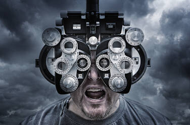 Illustration of man looking through optometrist equipment - BLEF07489