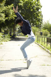 Black woman balancing on toes in park - BLEF07518