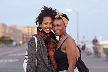 Afroamerikanische Freunde umarmen sich auf dem Bürgersteig - BLEF07527