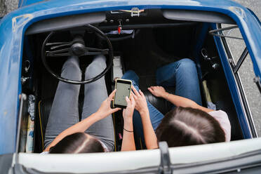 Friends using smartphone inside car - CUF51400