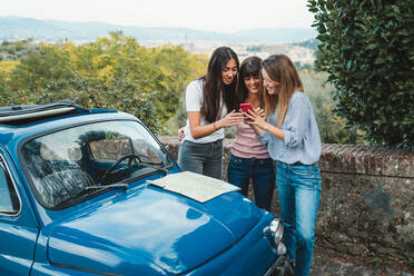 Freunde mit Smartphone auf dem Land, Florenz, Toskana, Italien - CUF51405