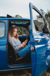 Frau benutzt Smartphone im Auto - CUF51414