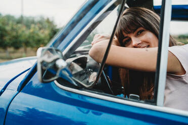 Woman leaning against steering wheel - CUF51420