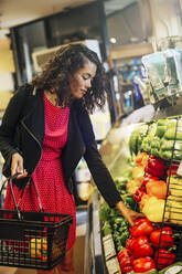 Gemischtrassige Frau beim Einkaufen im Lebensmittelgeschäft - BLEF07572