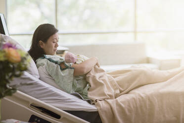 Mutter wiegt ihr neugeborenes Baby im Krankenhauszimmer - BLEF07605