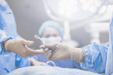 Chirurgen reichen Zangen im Operationssaal - BLEF07611