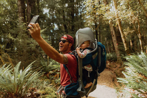 Vater mit Baby macht Selfie im Wald, Queenstown, Canterbury, Neuseeland, lizenzfreies Stockfoto