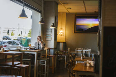 Young businesswoman with tablet in a bar - LJF00142