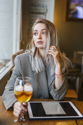 Junge Geschäftsfrau mit Tablet in einer Bar - LJF00150