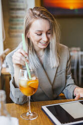 Junge Geschäftsfrau mit Tablet in einer Bar - LJF00152