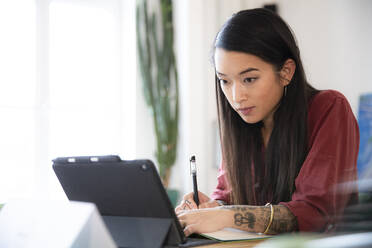 Woman using tablet in office - FKF03361