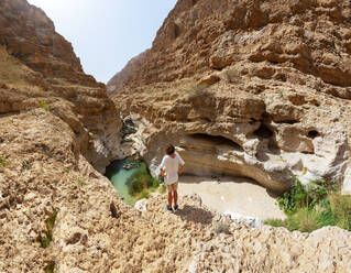 Man enjoying the view over Wadi Shab, Oman - WWF05133