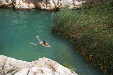 Mann schwimmt in einem kleinen See in Wadi Shab, Oman - WWF05137