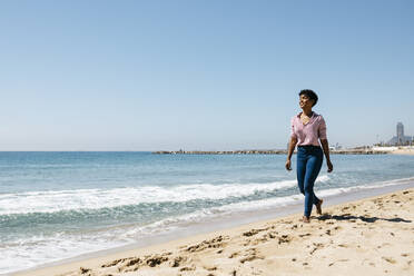 Frau, die nach der Arbeit am Strand spazieren geht und die Sonne genießt - JRFF03311