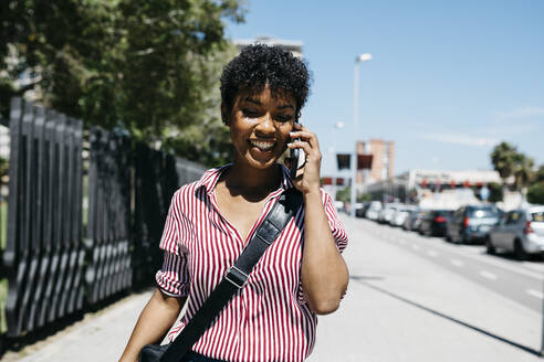 Frau telefoniert beim Spaziergang in der Stadt - JRFF03325