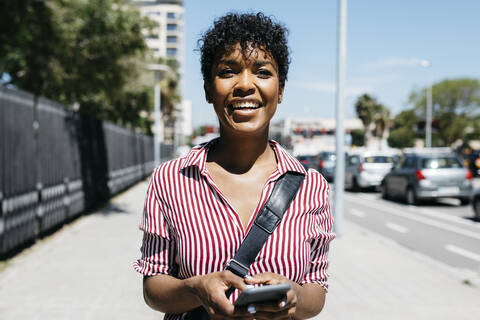 Woman using smartphone while walking in the city stock photo