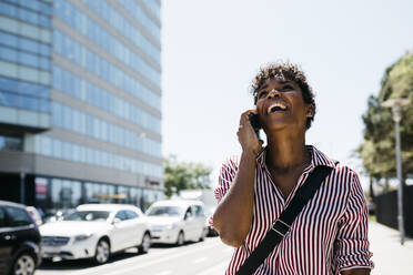 Woman talking on the phone while walking in the city - JRFF03328