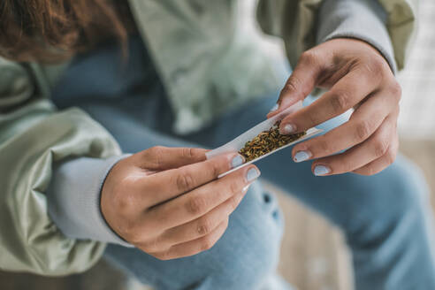 Woman's hands rolling a Marihuana joint, close-up - ACPF00555