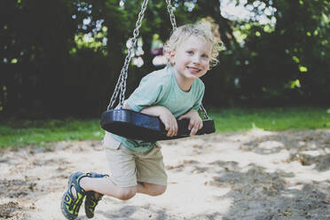 Portrait of little boy playing with swing - IHF00142