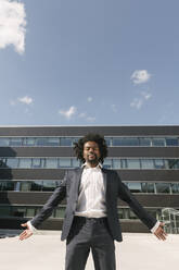 Businessman standing outside office with closed eyes - AHSF00529