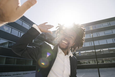 Happy businessman giving high-five outside office stock photo