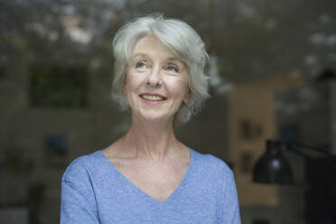 Portrait of content mature woman looking out of window - PNEF01687