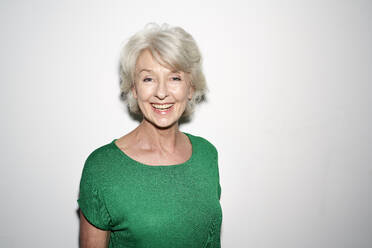 Portrait of laughing mature woman wearing green pullover - PNEF01701