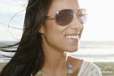 Mixed race woman smiling on beach - BLEF07621