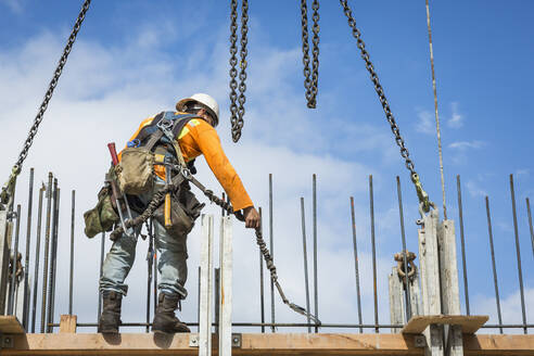 Caucasian worker holding chain at construction site - BLEF07637