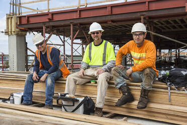 Lächelnde kaukasische Arbeiter auf einer Baustelle - BLEF07639