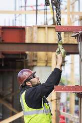 Kaukasischer Arbeiter hält Haken auf der Baustelle - BLEF07641