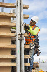 Hispanic worker holding hook at construction site - BLEF07645