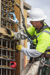 Caucasian worker examining wall at construction site - BLEF07646