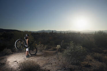 Mountainbiker in der Wüste stehend - BLEF07652