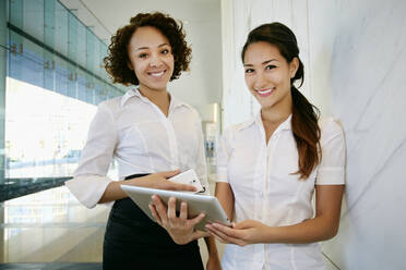 Geschäftsfrauen benutzen Tablet-Computer in der Lobby - BLEF07740