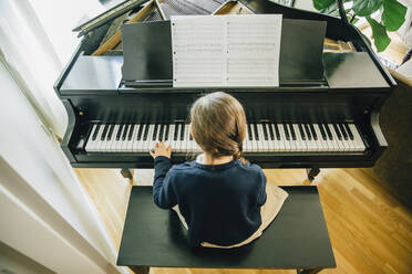 Gemischtrassiges Mädchen spielt Klavier - BLEF07784