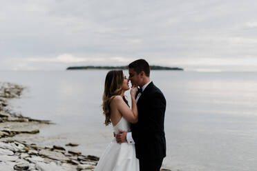 Romantische junge Braut und Bräutigam von Angesicht zu Angesicht am Seeufer - ISF21563