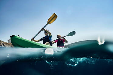 Teenage boy and mother sea kayaking on ocean, surface level view, Limnos, Khios, Greece - ISF21565