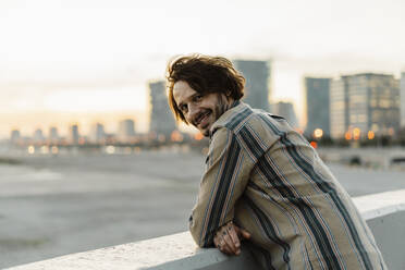 Portrait of smiling man relaxing during sunset, Barcelona, Spain - AFVF03333